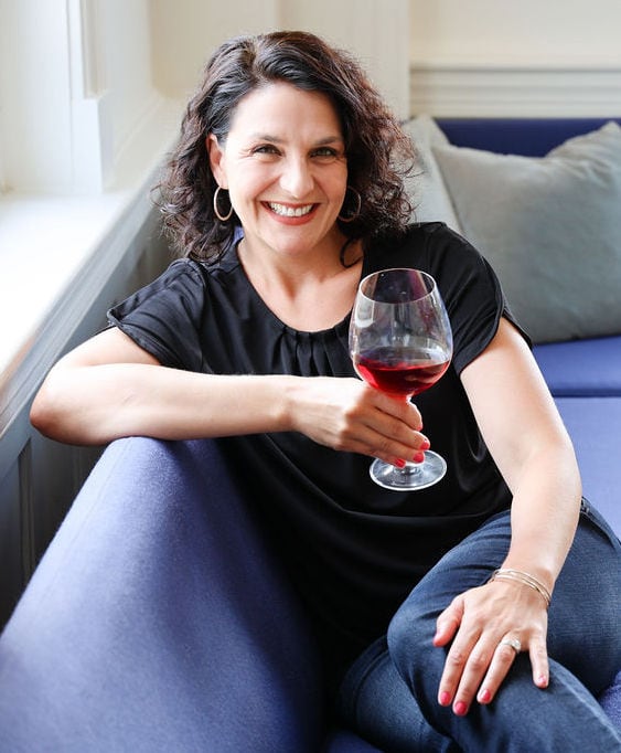 Elizabeth Schneider with a glass of red wine